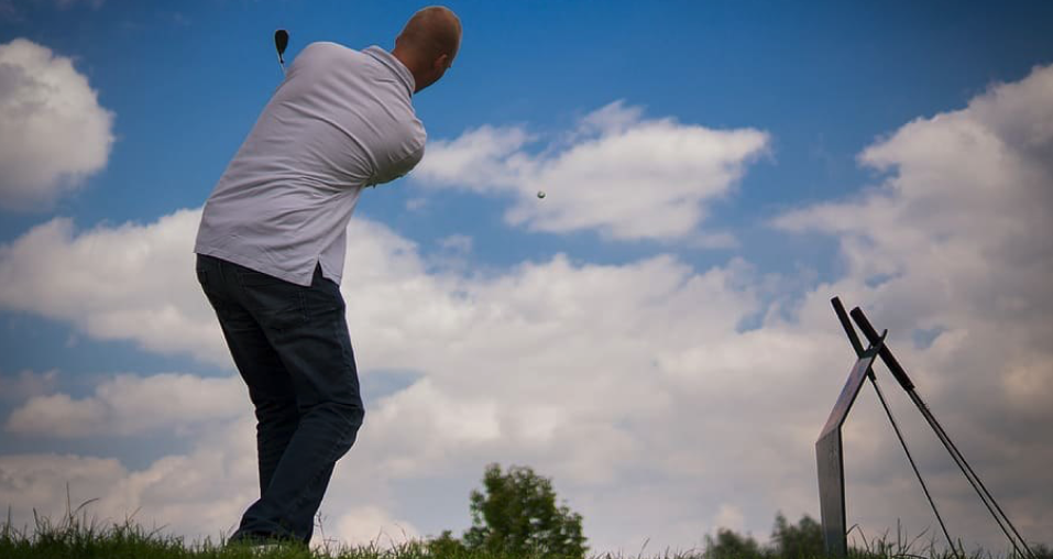  Image showing a low angle snap of a player playing his shot  where the ball is shown flying in the air representing the popular golf point game, Trouble